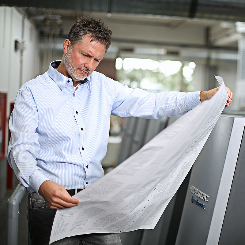 Ralf Trzeschewski prüft Druckauftrag – Produktioner & Printmanager